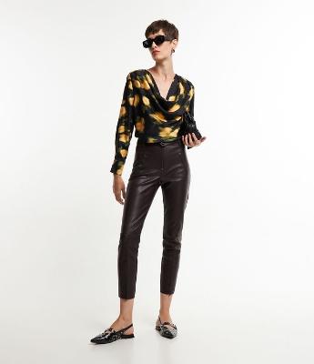 Calça Skinny em Material Sintético com Botão no Cós e Recortes